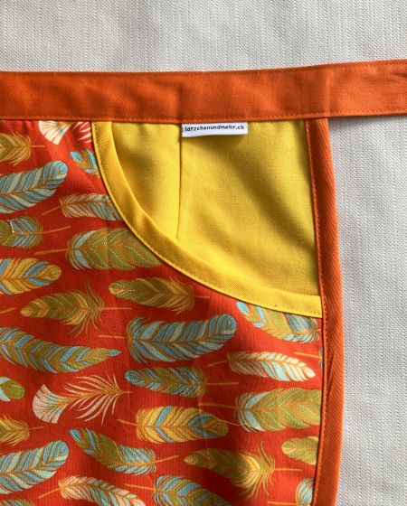 chlaemmerlisack_schuerze_orange_federn_detail_Tasche