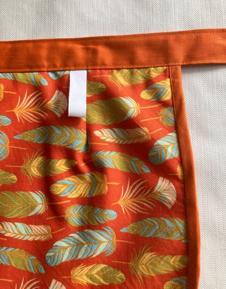 chlämmerlisack_schuerze_orange_federn_detail_aufhaenger